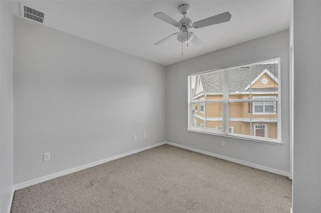 carpeted spare room featuring ceiling fan