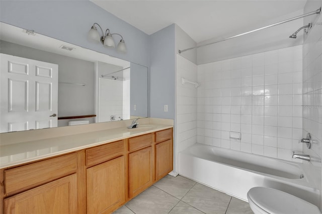 full bathroom featuring tile patterned flooring, vanity, tiled shower / bath, and toilet