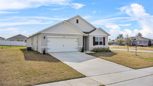 view of front of property featuring cooling unit, a garage, and a front yard