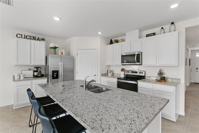 kitchen featuring white cabinetry, sink, stainless steel appliances, and a center island with sink