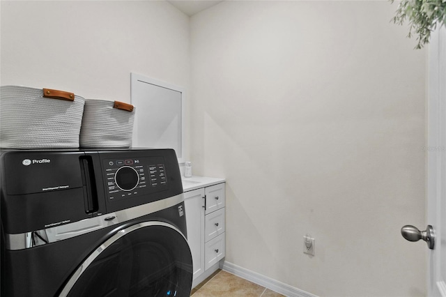 laundry room featuring cabinets, washer / dryer, and light tile patterned floors