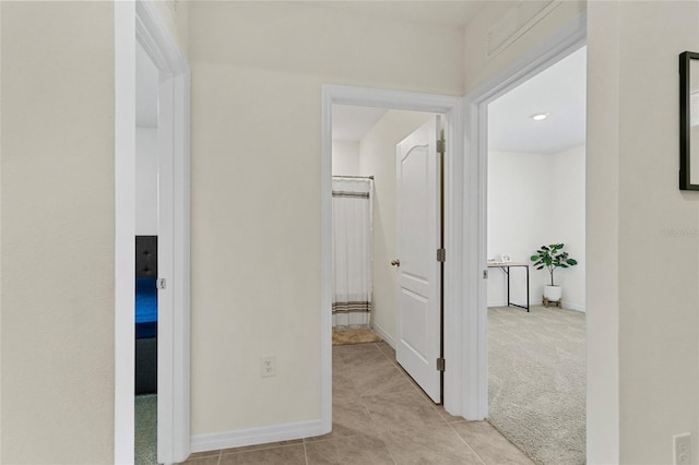 hallway featuring light colored carpet