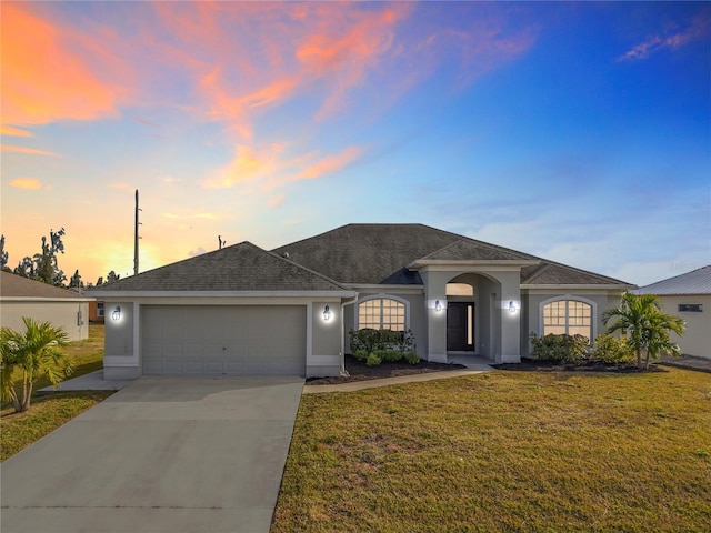 view of front of property with a garage and a lawn