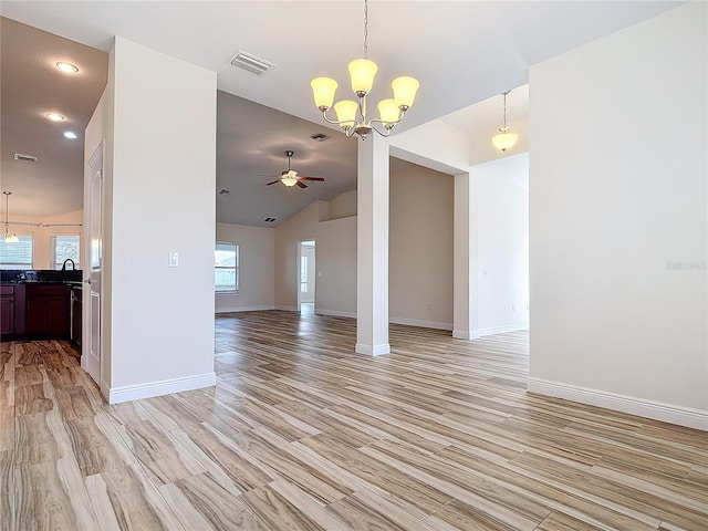 unfurnished living room featuring lofted ceiling, sink, ceiling fan with notable chandelier, and light hardwood / wood-style flooring