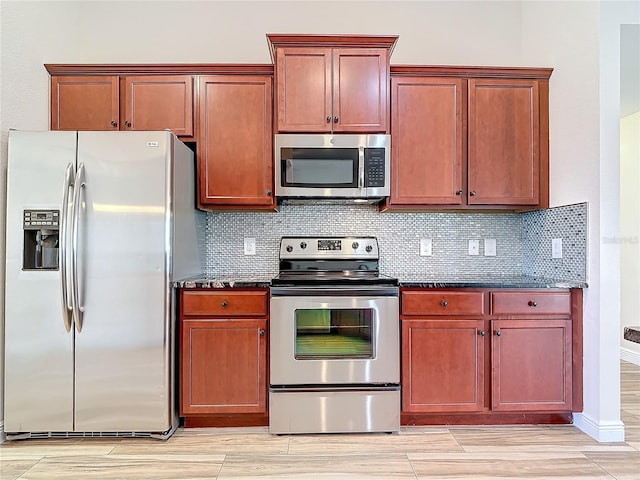 kitchen with tasteful backsplash, appliances with stainless steel finishes, and dark stone countertops