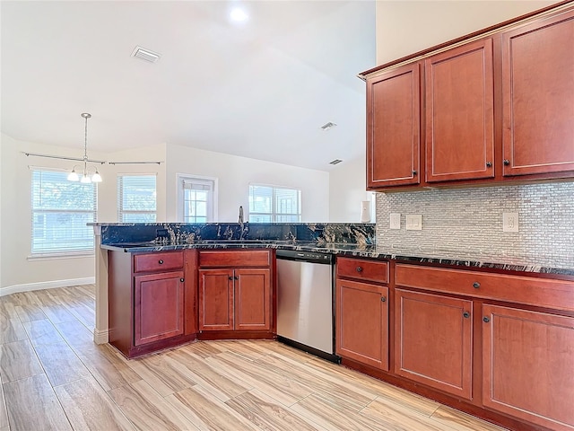 kitchen with lofted ceiling, hanging light fixtures, dark stone countertops, stainless steel dishwasher, and decorative backsplash