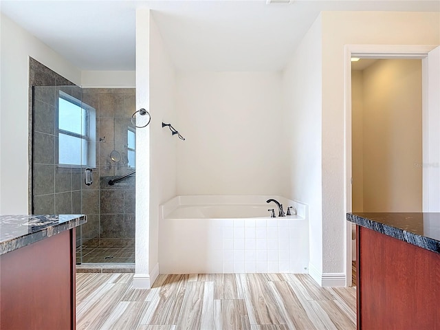 bathroom featuring vanity and separate shower and tub