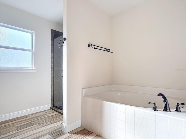 bathroom featuring separate shower and tub and hardwood / wood-style floors