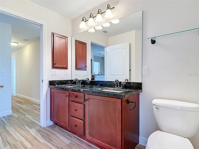 bathroom with hardwood / wood-style flooring, vanity, and toilet