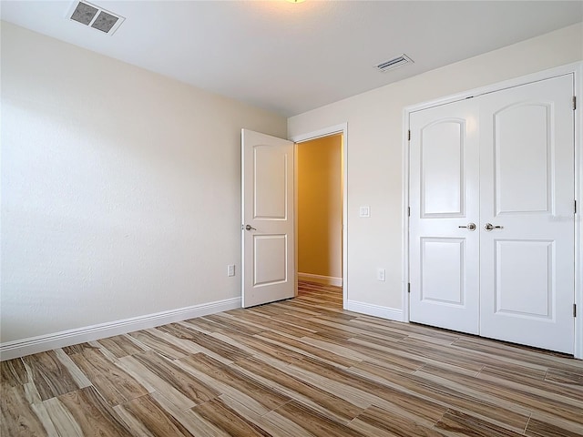 unfurnished bedroom featuring a closet and light wood-type flooring