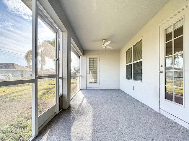 unfurnished sunroom featuring ceiling fan