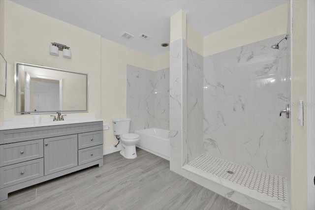 bathroom with hardwood / wood-style flooring, tiled shower, vanity, and toilet