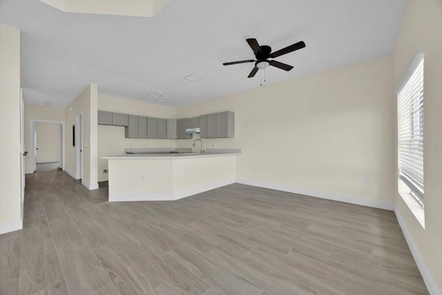 unfurnished living room featuring ceiling fan and light hardwood / wood-style floors