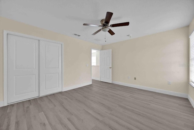 unfurnished bedroom featuring light hardwood / wood-style flooring, a closet, and ceiling fan