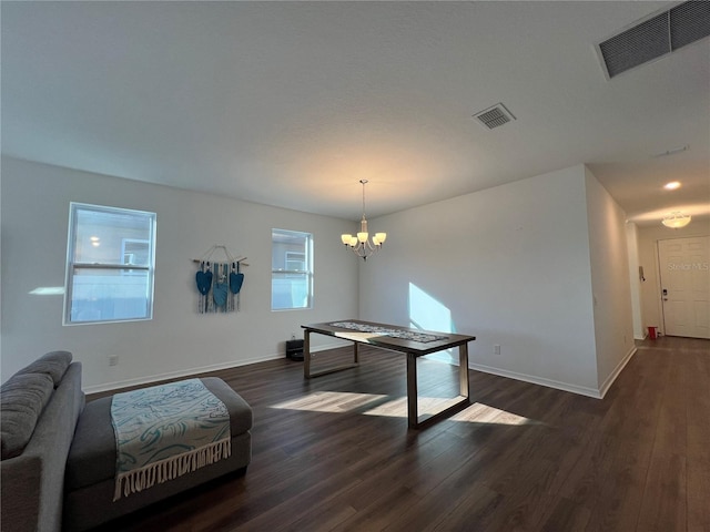 dining area with dark wood-type flooring, a chandelier, and a healthy amount of sunlight