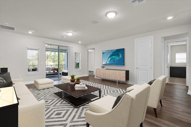 living room featuring dark wood-type flooring and plenty of natural light