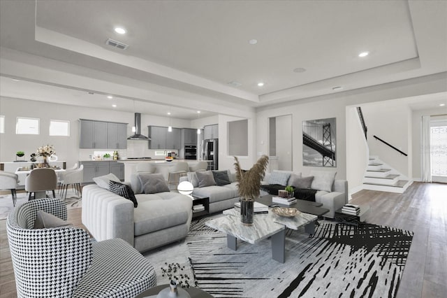 living room with hardwood / wood-style flooring and a raised ceiling