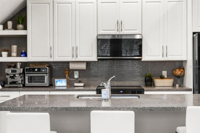 kitchen with sink, decorative backsplash, and white cabinets