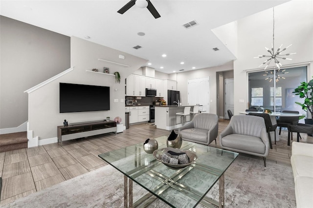 living room featuring ceiling fan with notable chandelier