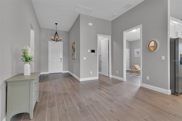 entryway with a notable chandelier and light wood-type flooring