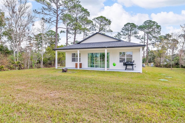 rear view of property with a yard and a patio