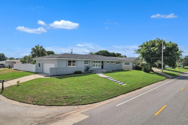 ranch-style house featuring a garage and a front lawn