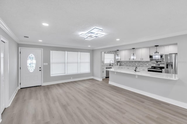 unfurnished living room featuring sink, ornamental molding, and light hardwood / wood-style floors