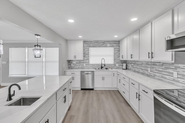 kitchen with stainless steel appliances, sink, and white cabinets