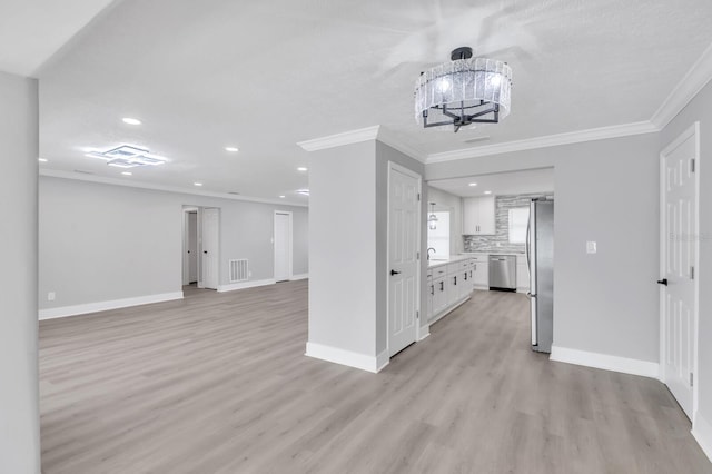 interior space with white cabinetry, light wood-type flooring, tasteful backsplash, and appliances with stainless steel finishes