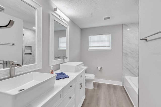 full bathroom featuring vanity, shower / bathing tub combination, wood-type flooring, a textured ceiling, and toilet