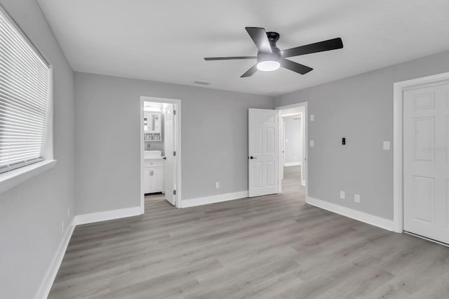 unfurnished bedroom featuring ceiling fan, connected bathroom, and light hardwood / wood-style flooring