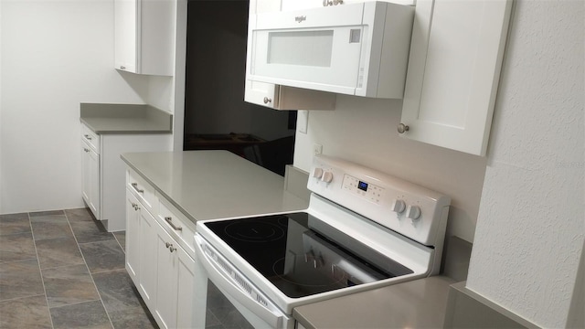 kitchen featuring white cabinetry and white appliances