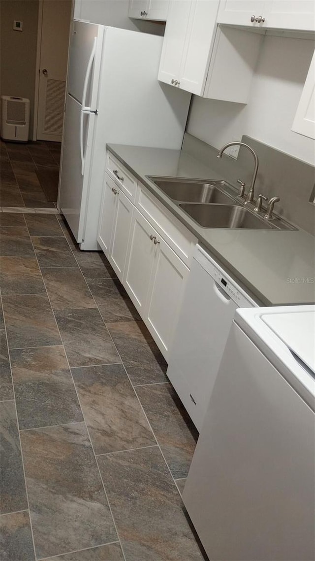 kitchen with white cabinetry, white dishwasher, washer / clothes dryer, and sink