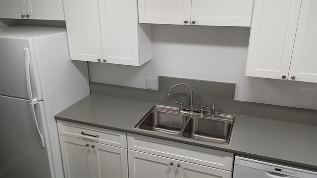 kitchen featuring white cabinetry, sink, stainless steel dishwasher, and white fridge