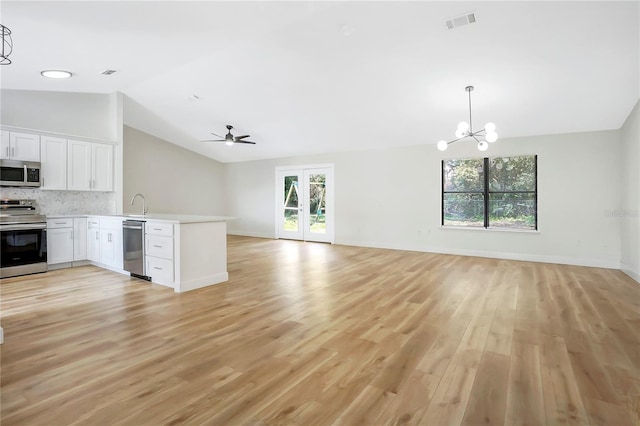 kitchen featuring lofted ceiling, white cabinetry, stainless steel appliances, kitchen peninsula, and light wood-type flooring