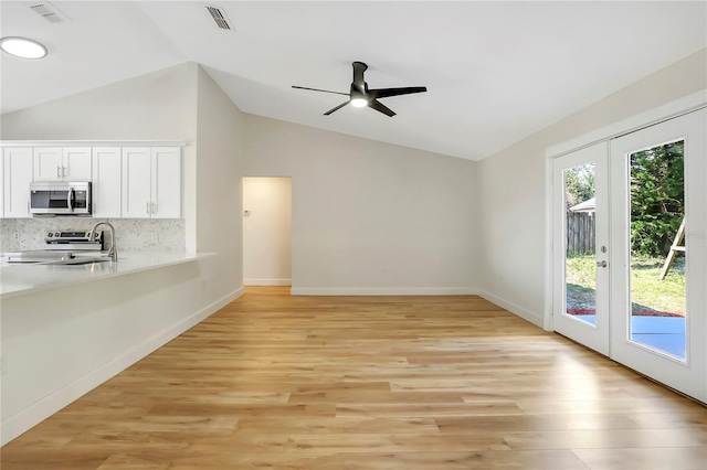 unfurnished living room with french doors, ceiling fan, lofted ceiling, and light hardwood / wood-style flooring