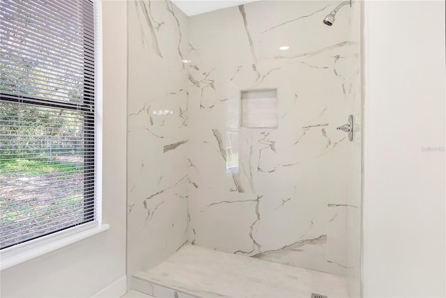 bathroom with a healthy amount of sunlight and tiled shower