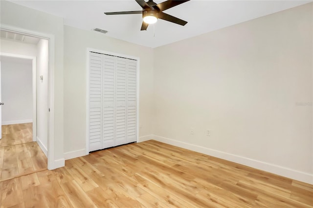 unfurnished bedroom featuring ceiling fan, hardwood / wood-style floors, and a closet