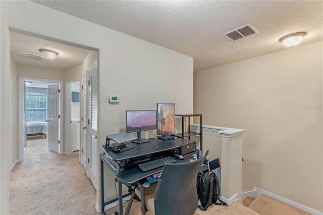 carpeted home office with a textured ceiling