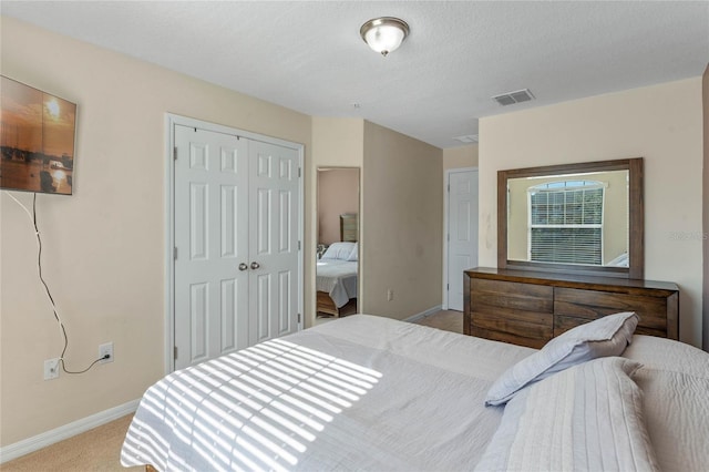 carpeted bedroom featuring a closet and a textured ceiling