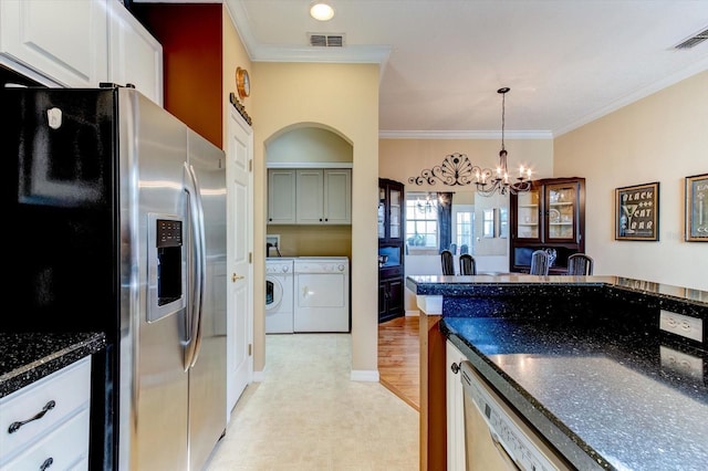 kitchen featuring white cabinetry, stainless steel fridge, ornamental molding, and independent washer and dryer