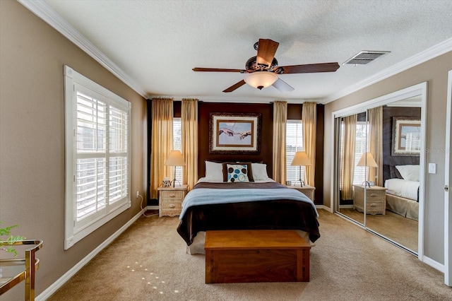 bedroom featuring crown molding, light colored carpet, a closet, and a textured ceiling