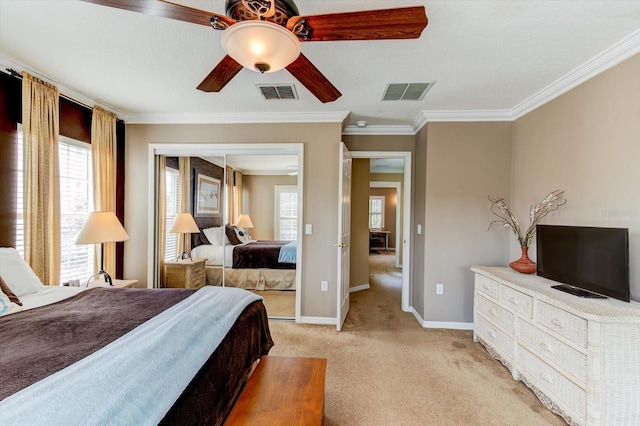 carpeted bedroom with crown molding, a closet, and ceiling fan