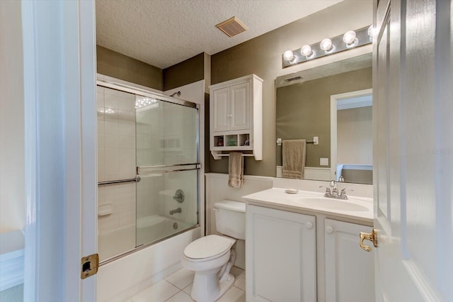 full bathroom featuring toilet, shower / bath combination with glass door, a textured ceiling, vanity, and tile patterned flooring