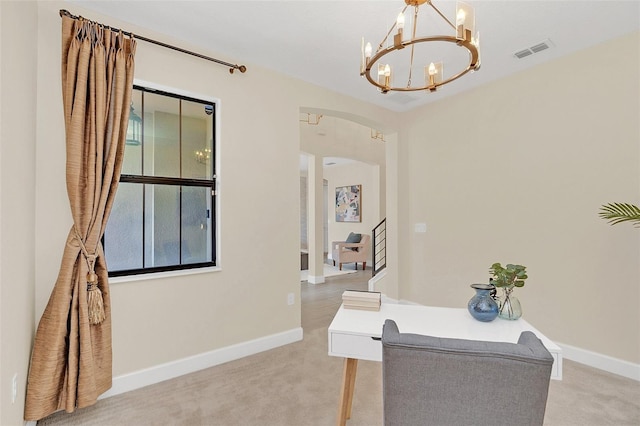 office space with light carpet and an inviting chandelier