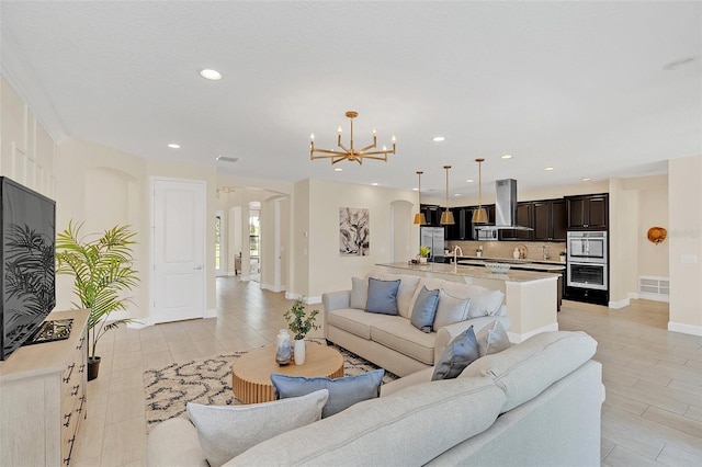 living room featuring sink and a notable chandelier