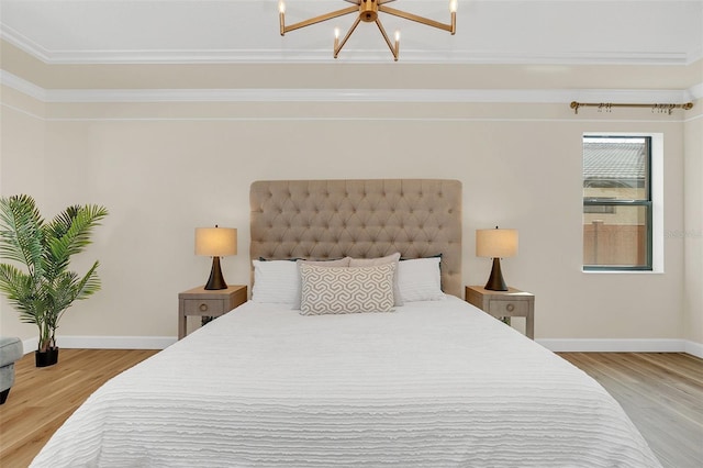 bedroom featuring ornamental molding, an inviting chandelier, and light hardwood / wood-style flooring