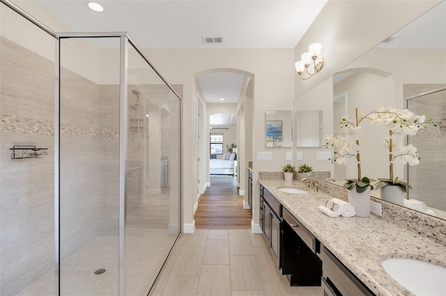 bathroom featuring vanity, an enclosed shower, and a textured ceiling