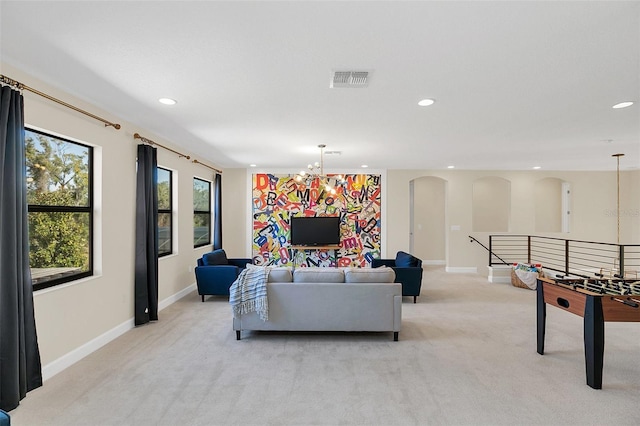 carpeted living room with a notable chandelier