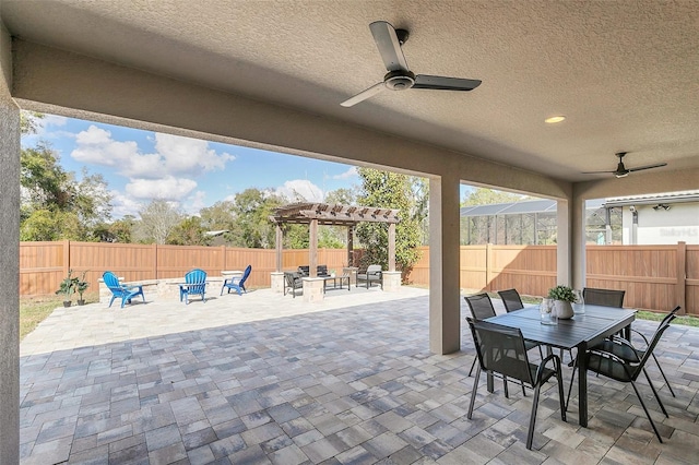 view of patio with ceiling fan, a pergola, and a fire pit